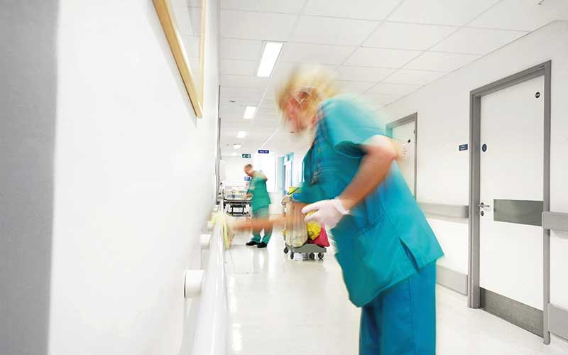 Nurse cleaning hospital corridor